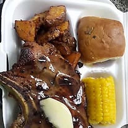 Barbecue ribs with potatoes, corn and a dinner roll