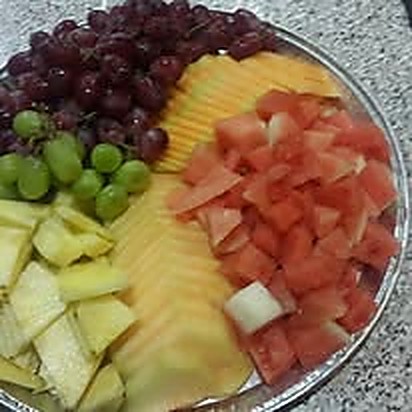 A fresh fruit platter with melon, grapes and pineapple